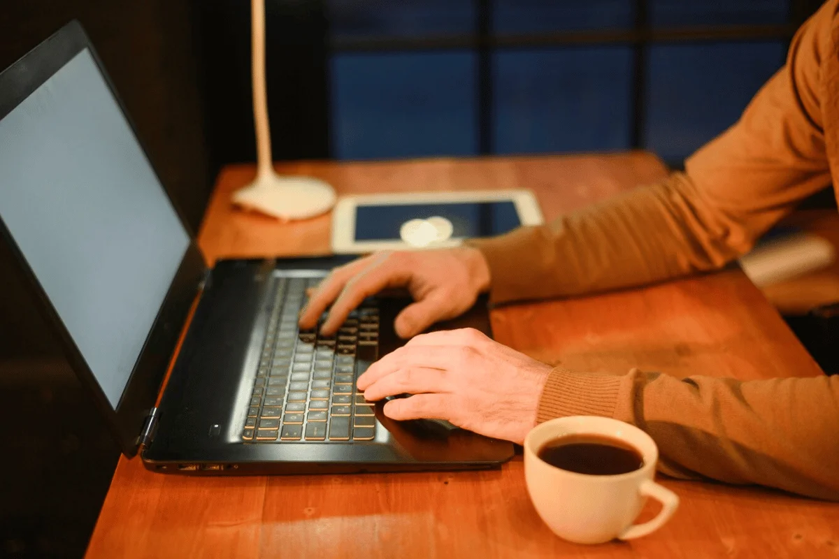 A man focused on his work, typing on a laptop computer with determination and concentration.