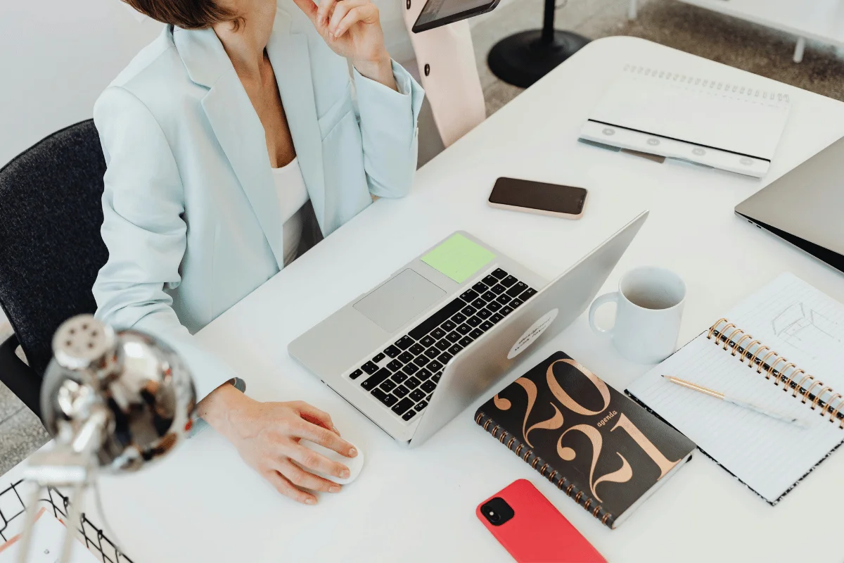 Top view of a woman working at her desk with office essentials.
