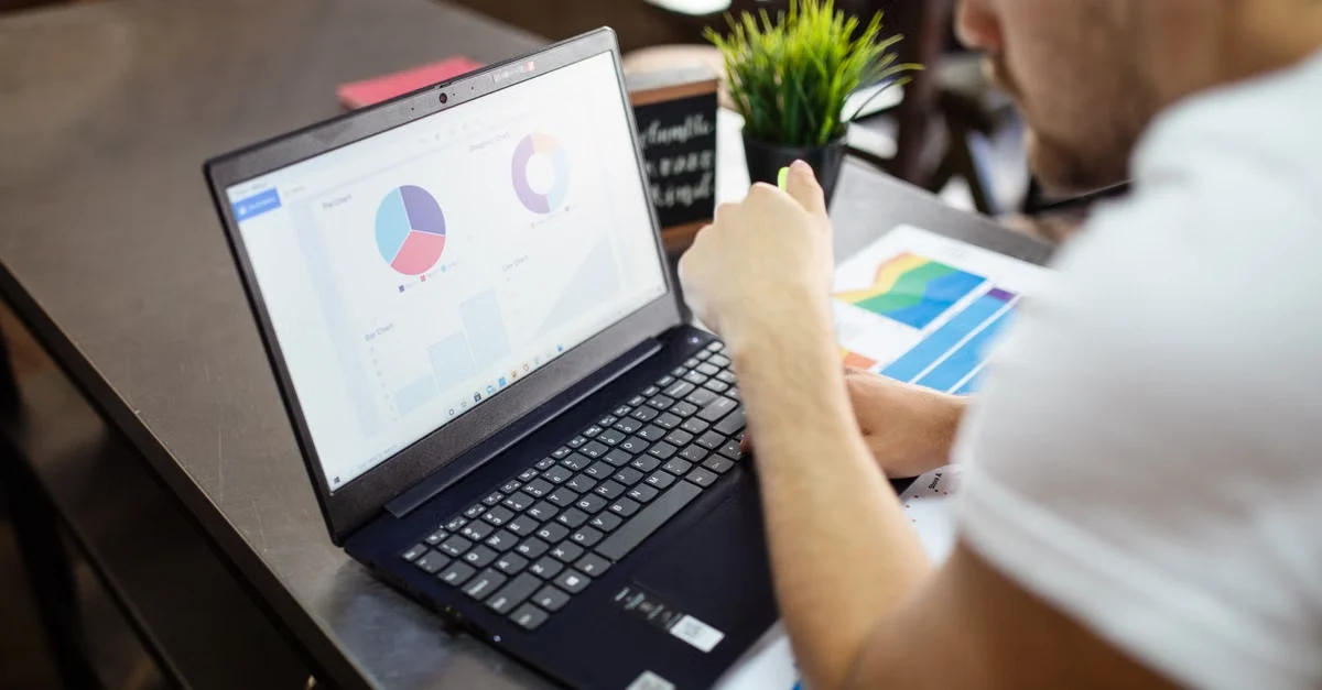 Designer analyzing colorful pie charts and analytics data on laptop screen for tacos amazon marketing strategy.